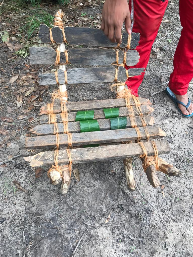 Cadeira rústica feita de tábuas e galhos amarrados com corda